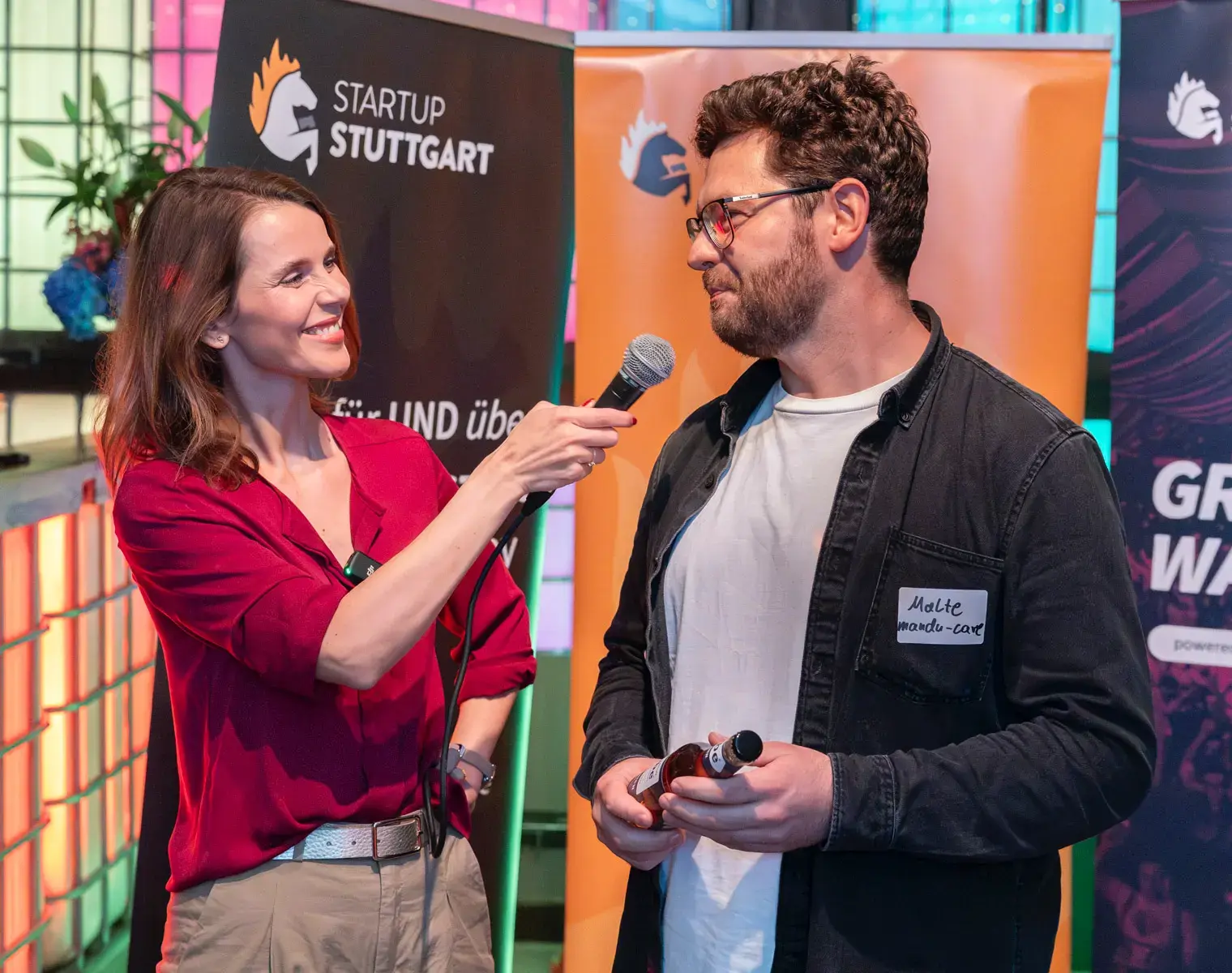 Franziska ZimmermannEvent Moderatorin in Stuttgart, während eines Interviews beim, Gründergrillen, im Hintergrund Rollups von Startup Stuttgart