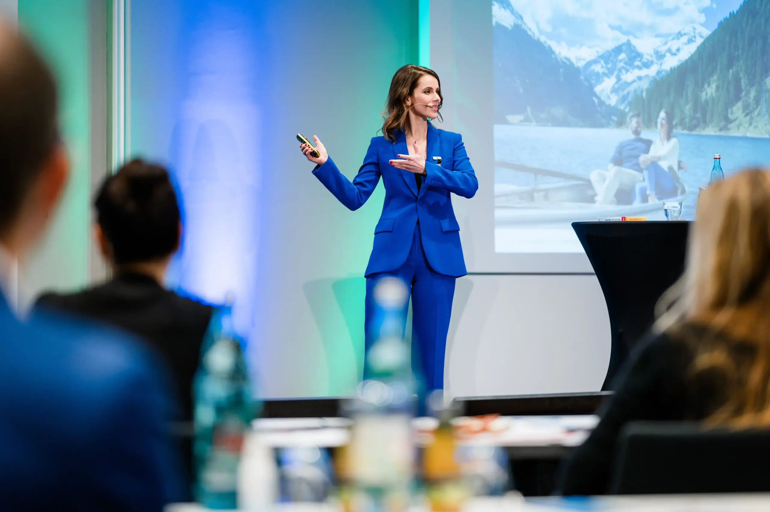 Keynote Speakerin Franziska Zimmermann in einem königsblauen Hosenanzug auf der Bühne während einer Präsentation